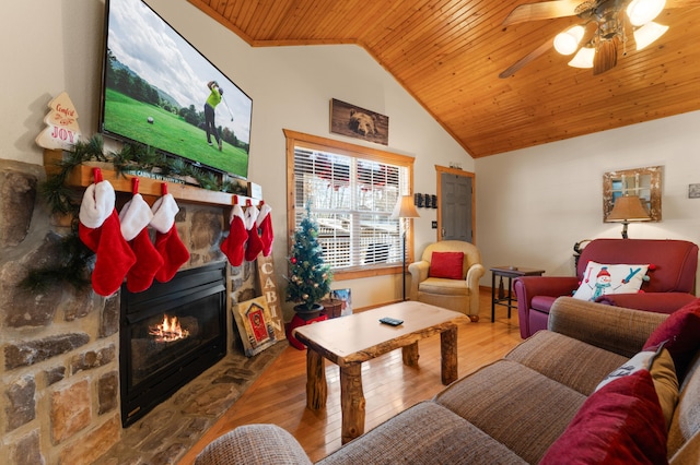 living room featuring a stone fireplace, wooden ceiling, wood-type flooring, ceiling fan, and lofted ceiling