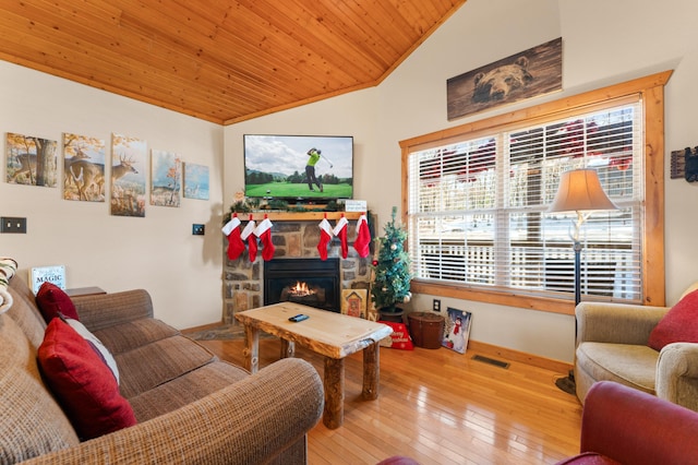 living room featuring vaulted ceiling, wooden ceiling, light hardwood / wood-style floors, and a fireplace