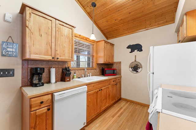 kitchen with pendant lighting, white appliances, lofted ceiling, sink, and backsplash