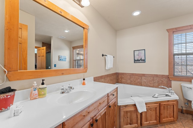 bathroom with vanity, toilet, a tub, and tile patterned floors