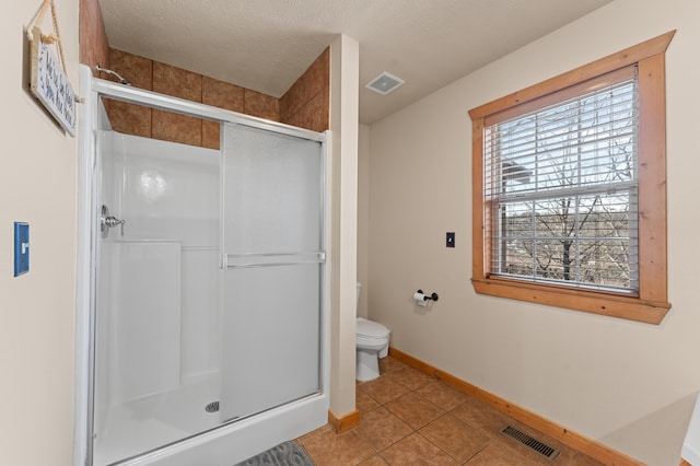 bathroom with tile patterned floors, toilet, and walk in shower