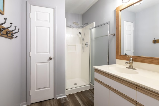 bathroom featuring hardwood / wood-style floors, an enclosed shower, and vanity