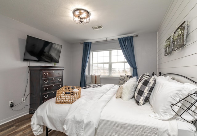 bedroom featuring hardwood / wood-style floors and wood walls