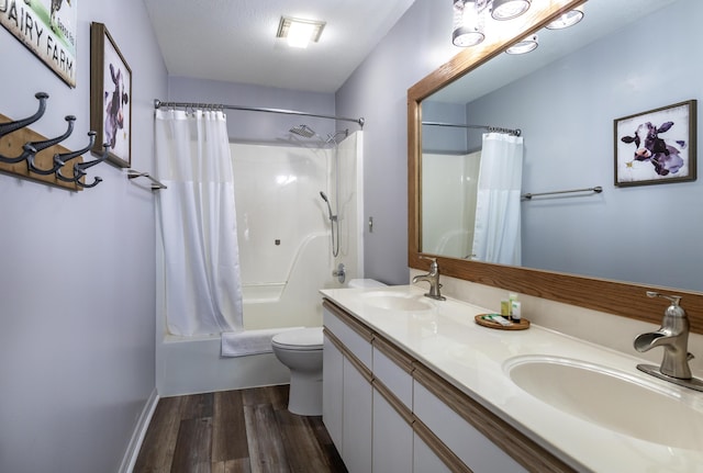 full bathroom featuring shower / tub combo, hardwood / wood-style flooring, a textured ceiling, toilet, and vanity