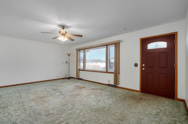 entrance foyer with ceiling fan and carpet flooring