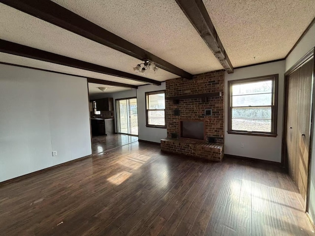 unfurnished living room featuring a textured ceiling, dark hardwood / wood-style floors, beam ceiling, and a fireplace