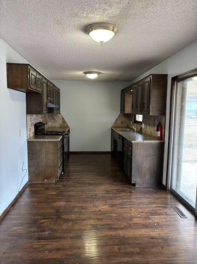 kitchen with dark hardwood / wood-style flooring, black range with electric cooktop, decorative backsplash, sink, and dark brown cabinets