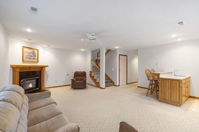 carpeted living room featuring sink and ceiling fan