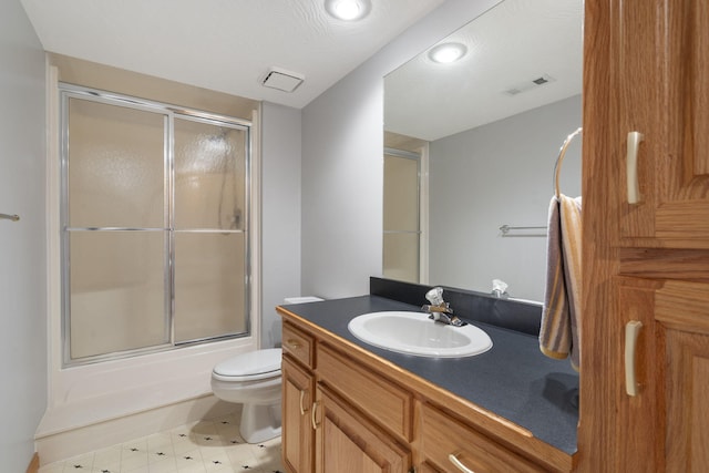 full bathroom featuring combined bath / shower with glass door, vanity, and toilet