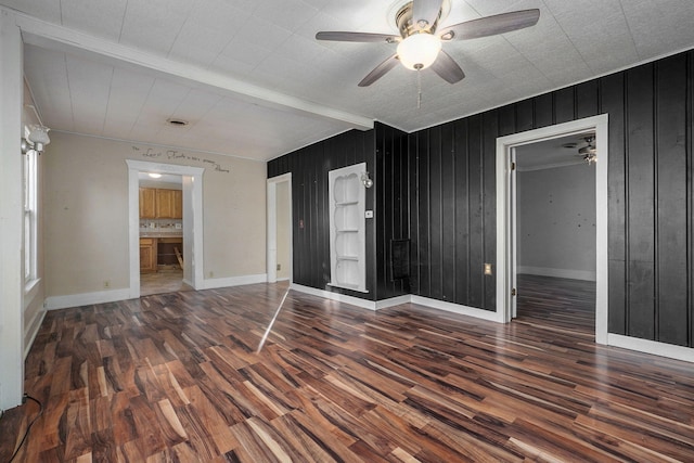 interior space featuring wood walls, dark wood-type flooring, beamed ceiling, and ceiling fan