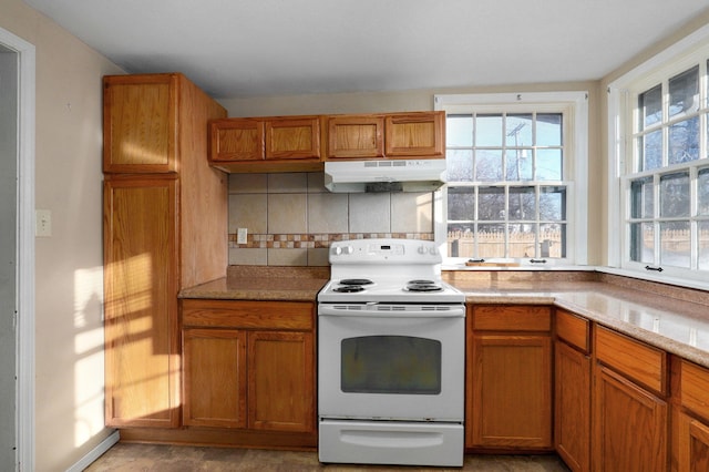 kitchen featuring light stone countertops, white electric range oven, and tasteful backsplash