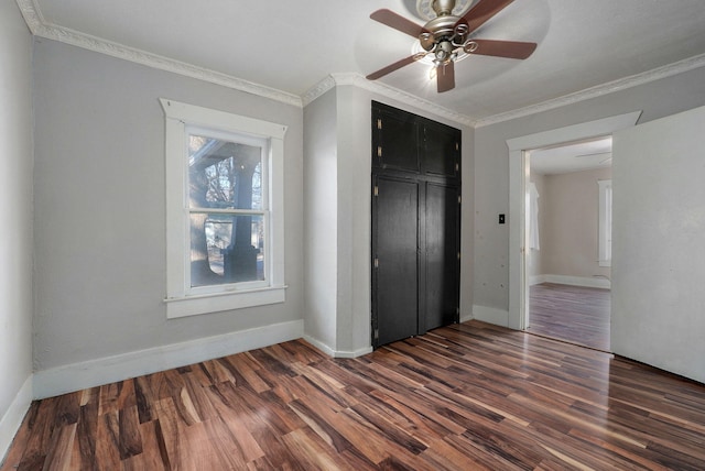 unfurnished bedroom with ceiling fan, dark hardwood / wood-style floors, a closet, and crown molding