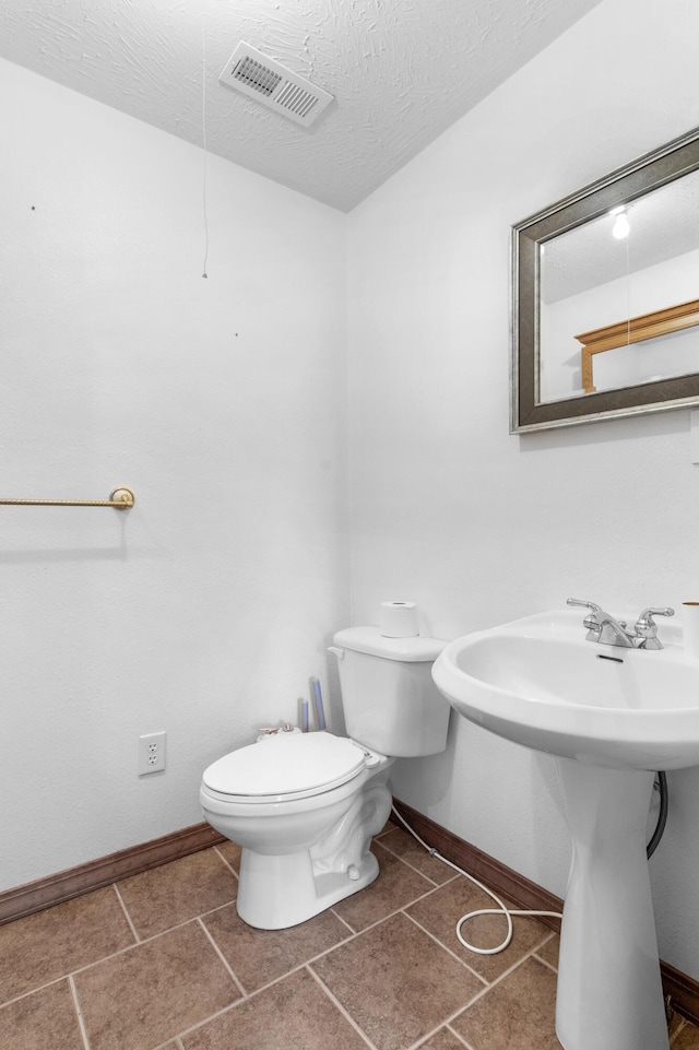 bathroom with toilet and a textured ceiling