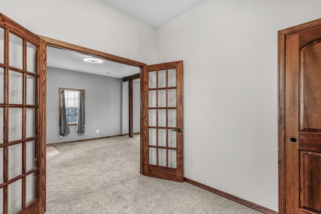 empty room with french doors and light colored carpet