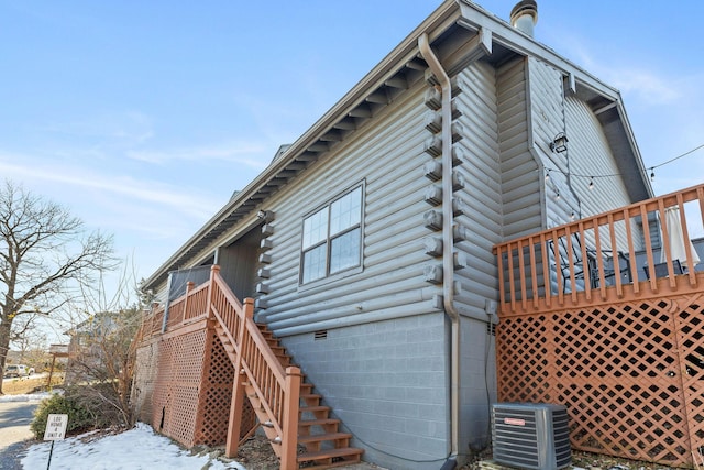 view of snowy exterior featuring a deck and central AC