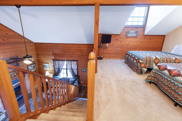 bedroom with light carpet, wood walls, multiple windows, and ceiling fan