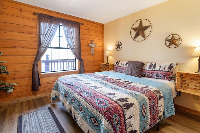 bedroom with wood walls and hardwood / wood-style flooring