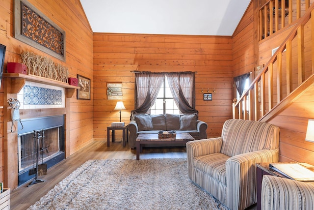 living room featuring hardwood / wood-style flooring, wooden walls, and vaulted ceiling