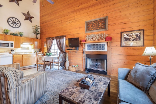 living room featuring hardwood / wood-style flooring, a towering ceiling, and ceiling fan