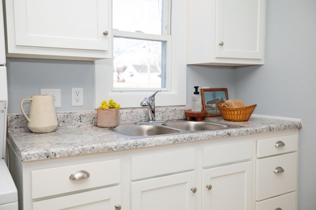 kitchen featuring sink and white cabinets