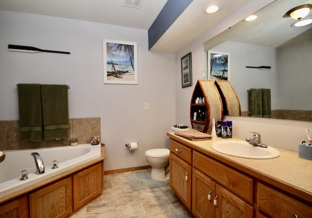 bathroom with vanity, a washtub, and toilet