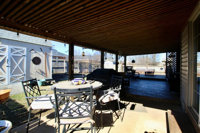 view of patio featuring a storage unit and a deck