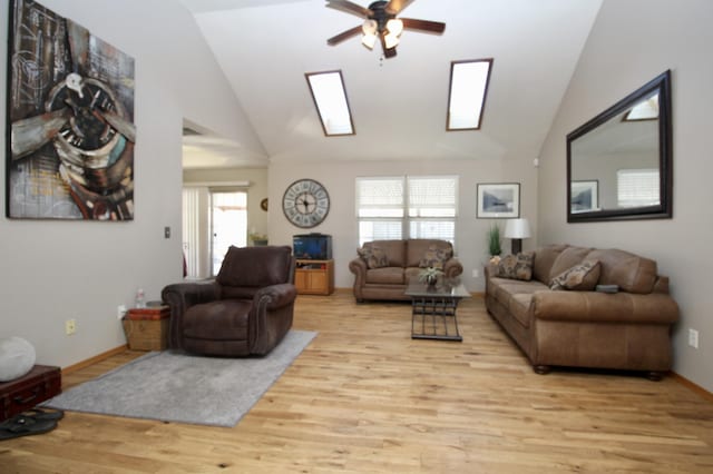 living room with ceiling fan, lofted ceiling with skylight, a healthy amount of sunlight, and light hardwood / wood-style floors