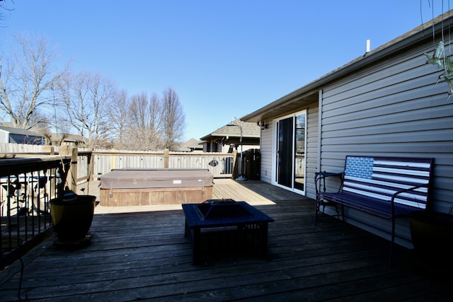 wooden deck featuring an outdoor fire pit and a hot tub