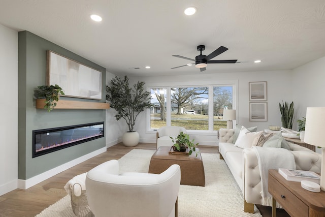 living room with ceiling fan and light hardwood / wood-style flooring