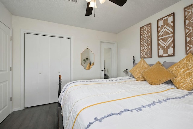 bedroom with a closet, ceiling fan, dark wood-type flooring, and a textured ceiling