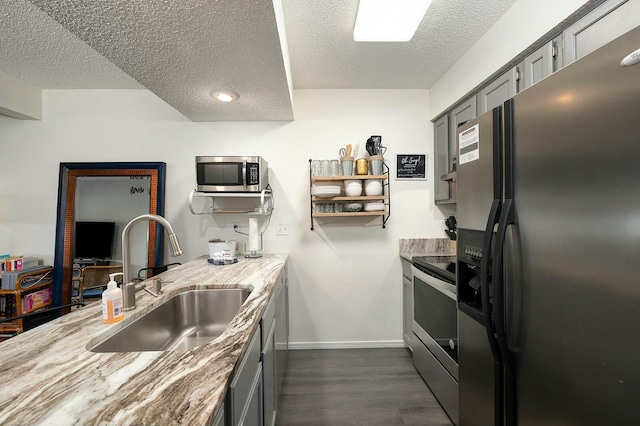 kitchen featuring sink, a textured ceiling, gray cabinetry, and stainless steel appliances