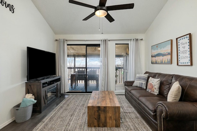 living room featuring a textured ceiling, vaulted ceiling, ceiling fan, and dark hardwood / wood-style flooring