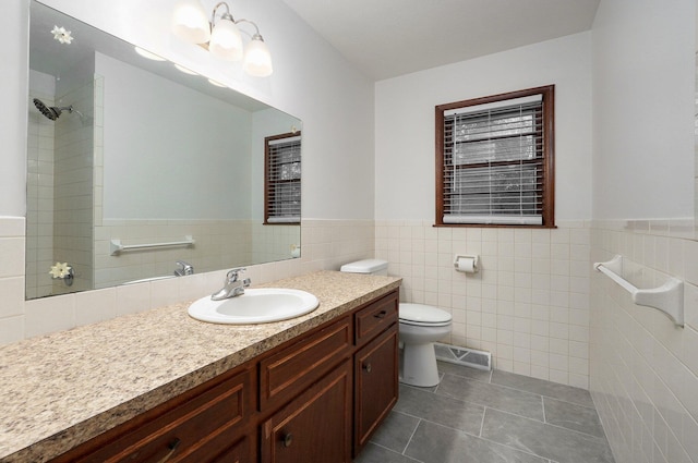 bathroom featuring tile patterned floors, toilet, tile walls, and vanity