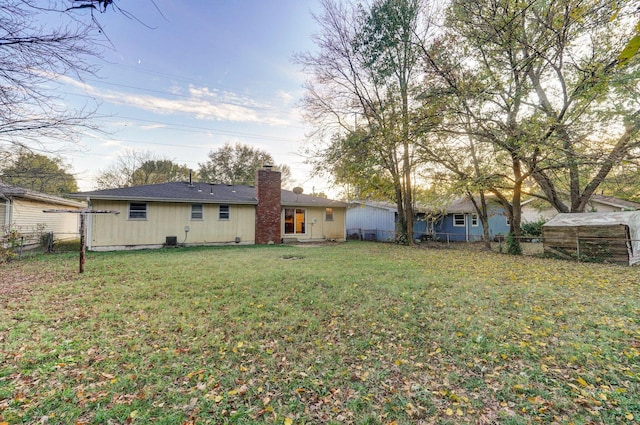 rear view of house featuring a yard