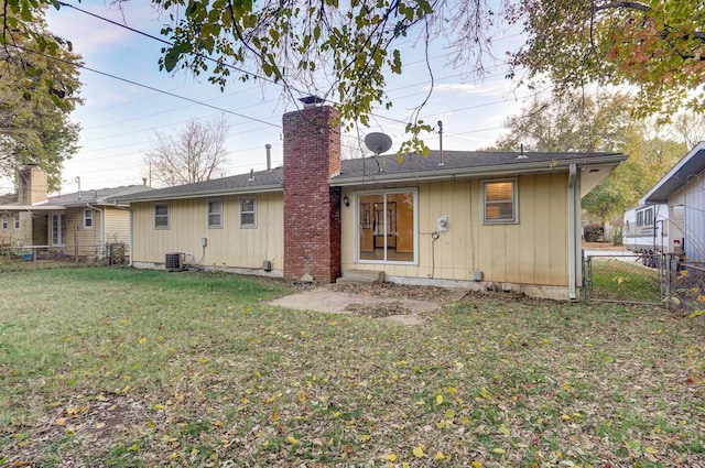 rear view of property featuring a yard and central AC