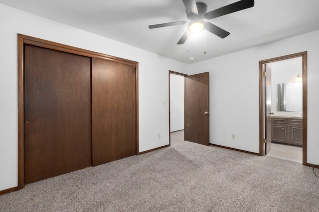 unfurnished bedroom with light carpet, a closet, ceiling fan, and connected bathroom