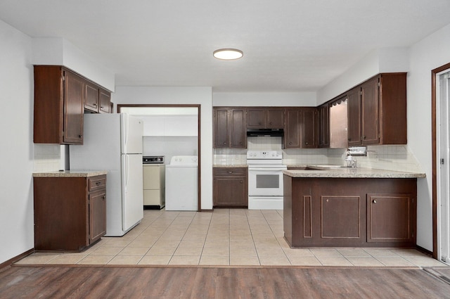 kitchen featuring white appliances, light hardwood / wood-style floors, dark brown cabinets, washer and clothes dryer, and kitchen peninsula