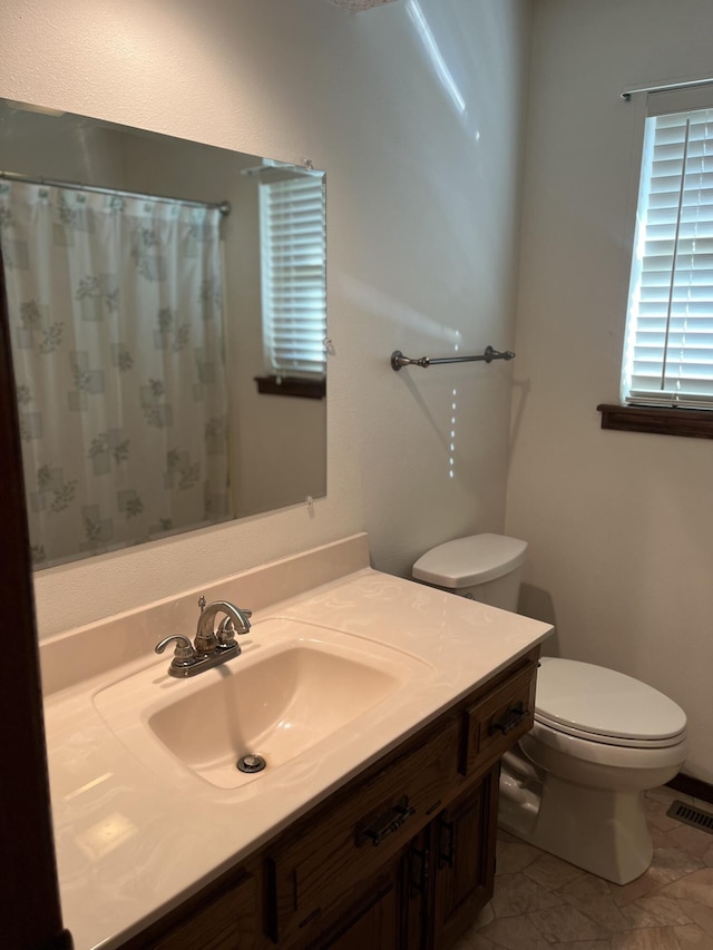 bathroom with toilet, vanity, a shower with shower curtain, and tile patterned flooring