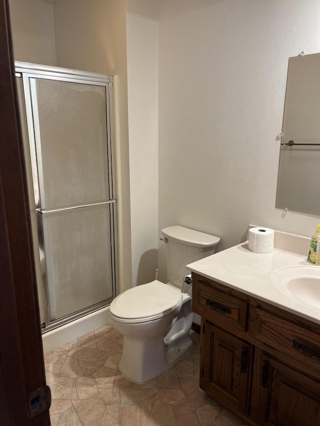 bathroom featuring toilet, an enclosed shower, and vanity