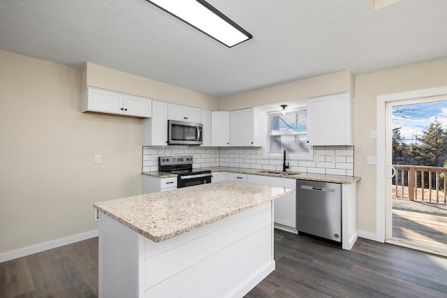 kitchen featuring sink, white cabinetry, a center island, and appliances with stainless steel finishes