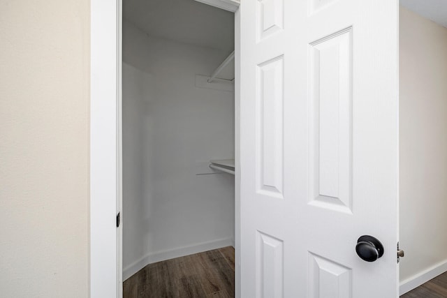 spacious closet with dark hardwood / wood-style flooring