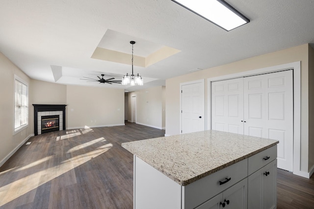 kitchen with a center island, hanging light fixtures, and a raised ceiling