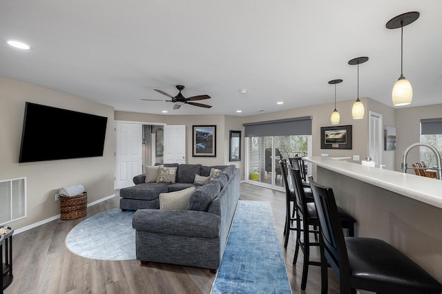 living room featuring sink, ceiling fan, a wealth of natural light, and dark hardwood / wood-style flooring