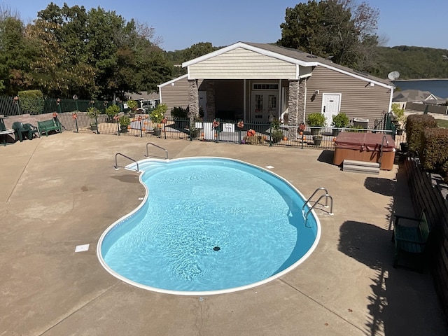 view of swimming pool featuring a patio area and a hot tub