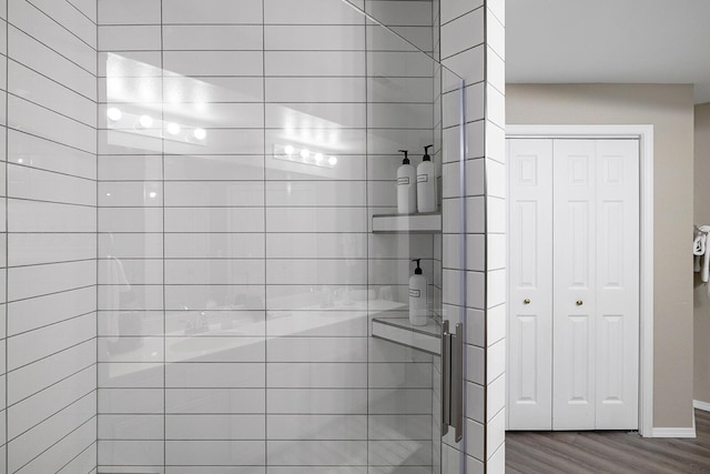 bathroom with hardwood / wood-style floors and tiled shower