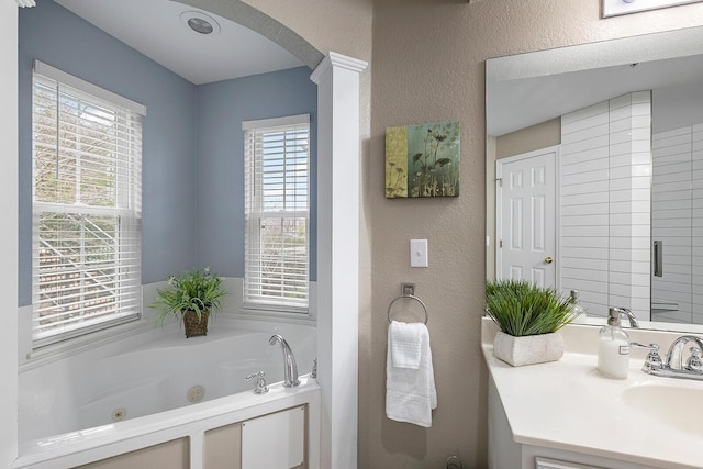 bathroom with a tub to relax in and vanity