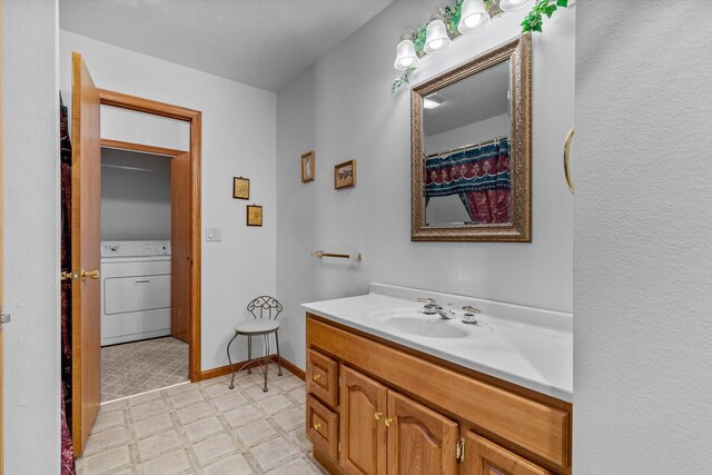 bathroom featuring vanity and washer / dryer