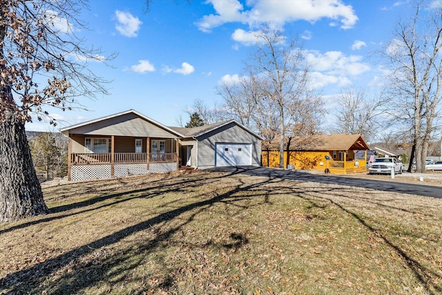 single story home with covered porch, a garage, and a front lawn