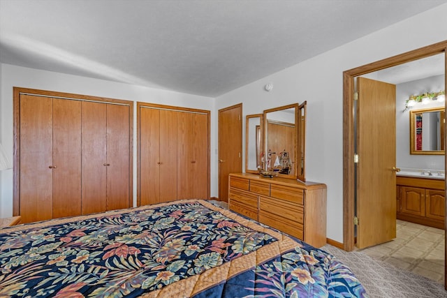 bedroom with two closets and connected bathroom