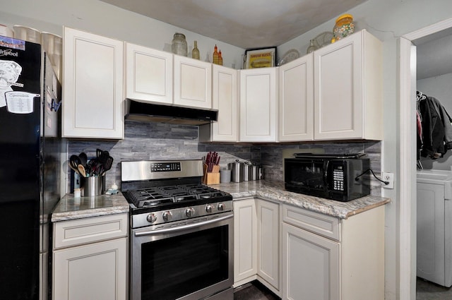 kitchen featuring black appliances, washer / dryer, light stone countertops, decorative backsplash, and white cabinets